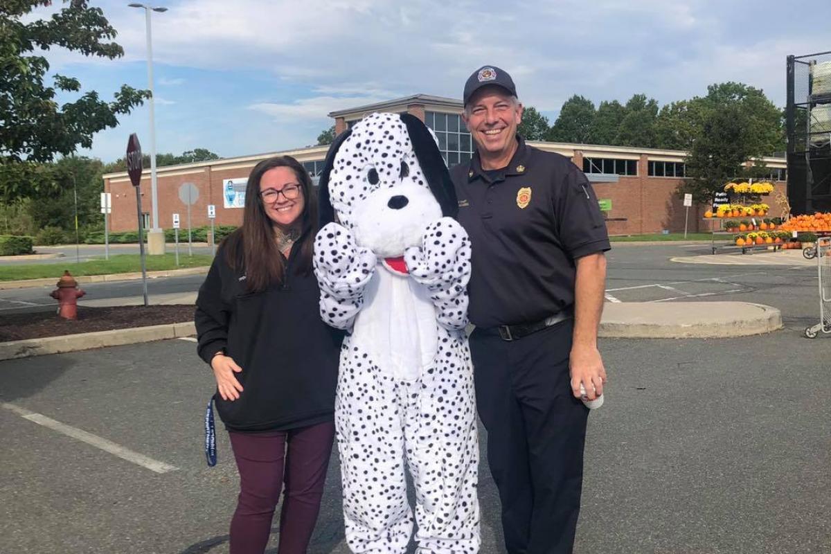 Home Depot's mascot Dalmatian posing with Fire Chief Spanknebel and PD Admin Ass't Lauren