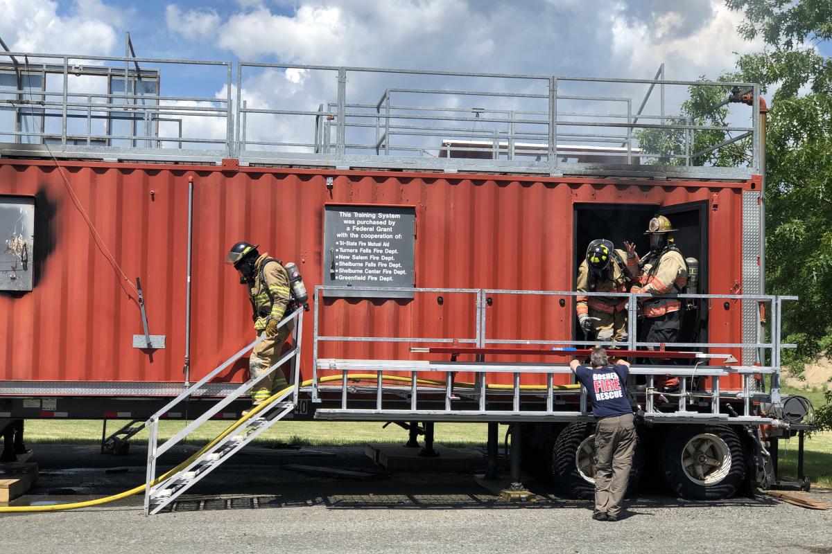 Participants exiting the red fire training trailer.
