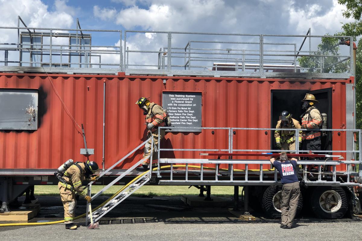 Participants exiting the red fire training trailer.